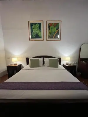 a bedroom with a large white bed with two lamps at East Indies Mansion in George Town
