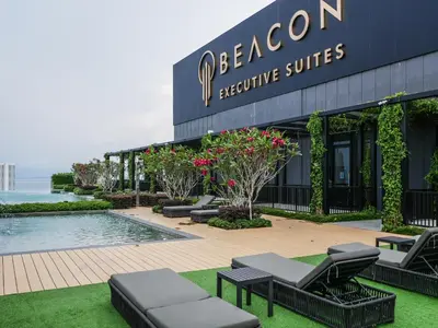 a resort building with chairs and a swimming pool at Comfy Stay at Beacon#6pax#2carpark#SunsetView#Georgetown in George Town