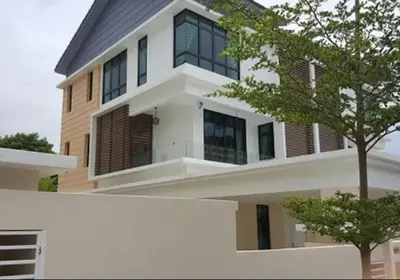 a large white house with a tree in front of it at Pearl Residences Sleep 27 in Batu Ferringhi