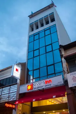 a tall building with a sign on a street at Apollo Inn in George Town