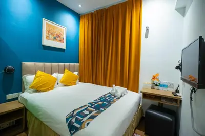 a bedroom with a bed with yellow and blue walls at Apollo Inn in George Town