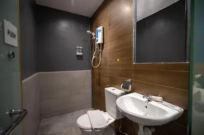 a bathroom with a sink and a toilet and a mirror at Apollo Inn in George Town