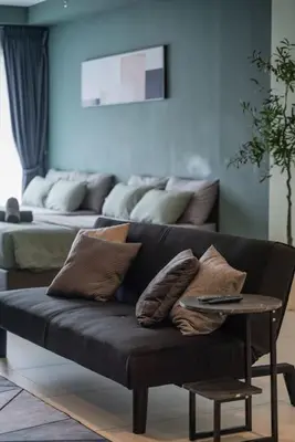 a black couch with pillows and a table in a living room at Deluxe Seaview Suite Twin Bed by The Only Bnb in Tanjong Tokong
