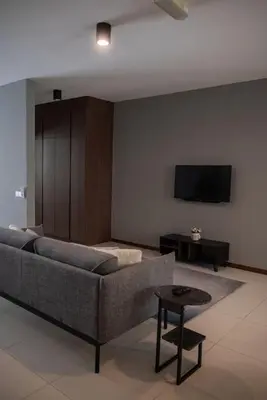 a living room with a couch and a tv at Deluxe Seaview Suite Twin Bed by The Only Bnb in Tanjong Tokong