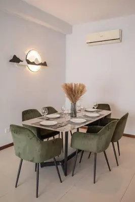 a dining room with a table and green chairs at Family Seaview Suite with 3 Rooms by The Only Bnb in Tanjong Tokong