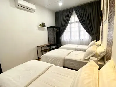 a hotel room with three beds and a window at comfy 3-bedrooms with family karaoke Max-10pax in Ipoh