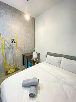 a bedroom with a large white bed and a desk at Kota Permai Free n Easy Interior Bukit Mertajam in Bukit Mertajam