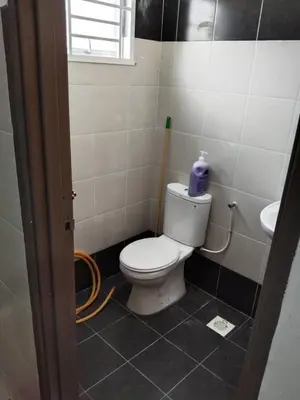 a bathroom with a white toilet and a sink at Abah StayCation in Sungai Besar