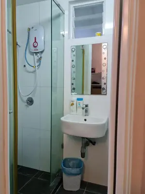 a bathroom with a sink and a shower with a mirror at Maritime Karpal Singh in George Town