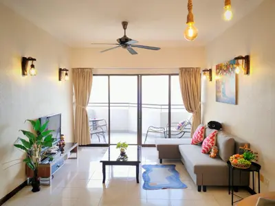a living room with a couch and a tv at InvincibleSeaview Batu Ferrighi Sri Sayang \u7121\u6575\u6d77\u666f 2-7 in Batu Ferringhi