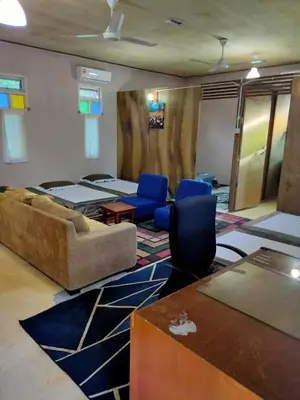 a living room with a couch and blue chairs at Anjung Afilia 1 in Kuala Kangsar
