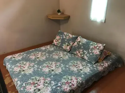 a bed with a floral bedspread and a pillow at Afilia 2 in Kuala Kangsar