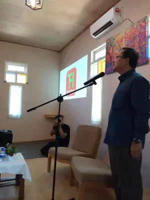 a man standing in a room with a microphone at Afilia 2 in Kuala Kangsar