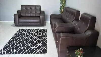 two leather chairs and a table in a living room at RUMAH INAP BANDAR PERDANA in Sungai Petani