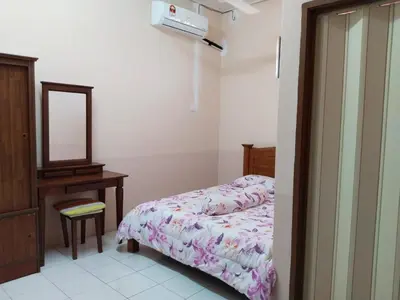 a bedroom with a bed and a dresser and a mirror at Homestay YatiMizi (Bungalow Station 18, Ipoh) in Ipoh