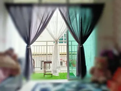 a window with curtains and a table and a building at Deq Noor Homestay in Cameron Highlands