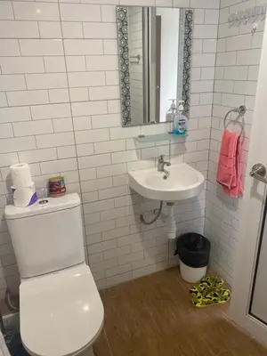 a white bathroom with a toilet and a sink at Susies Deluxe Seaview Suite Sri Sayang in Batu Ferringhi