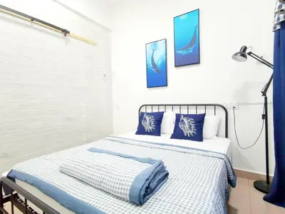 a bedroom with a bed with blue and white sheets at 527 BeachHouse l 5 bedroom with swimming pool - 3min walk to the beach in Tanjung Bungah