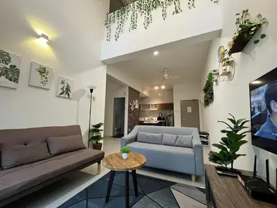 a living room with two couches and a table at Aloft Cameron Highland in Brinchang