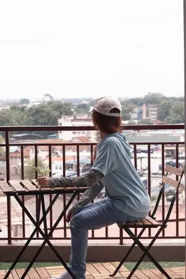 a woman sitting at a picnic table on a balcony at THE MAJESTIC IPOH A8 by ZamanJa in Ipoh
