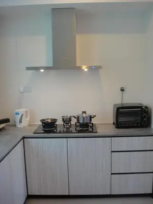 a kitchen with a stove and a microwave at Shamrock Beach Villas Batu Ferringhi Penang in Batu Ferringhi