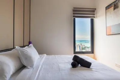 a bedroom with a white bed with a large window at Executive Seaview 2Bedrooms Macalister Georgetown 4-6pax in George Town