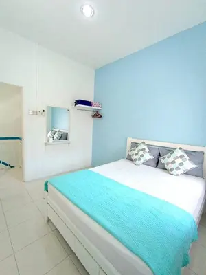 a bedroom with a bed with a blue wall at Santorini 4 Bedrooms Full Air Cond Entire Home by Grab A Stay in Ipoh