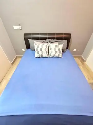 a bed with blue sheets and pillows in a room at Octagon Premium Ipoh Town Center 2BR 101 by Grab A Stay in Ipoh