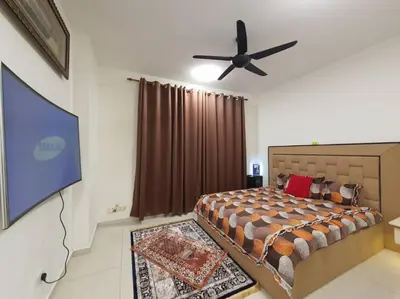a bedroom with a bed and a flat screen tv at HOMESTAY EPOH Meru Raya in Ipoh