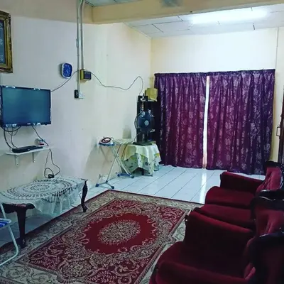 a living room with a red couch and a tv at Homestay Musafir 3.0 in Seri Iskandar