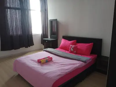 a bedroom with a large bed with pink pillows at Taiping Comfort Condo Homestay in Taiping