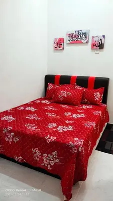 a bed with a red comforter and red pillows at Rania Homestay With Private Pool Seri Iskandar Perak Near UTP UITM in Kampong Bota Road