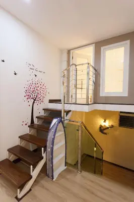 a room with a staircase with a tree mural on the wall at Pearl Rice Garden \uff08cottage style\uff09\u7c73\u6a02\u574a\u9802\u5c64\u7530\u56ed\u5f0f\u9ad8\u7ea7\u516c\u5bd3 in Sekincan