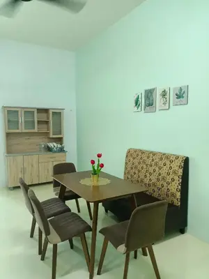 a dining room with a wooden table and chairs at Homestay Muslim in Kuala Ketil