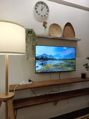a flat screen tv sitting on a shelf with a clock at UNESCO Bohemian Style Heritage House at Georgetown 5BR 14 pax in George Town
