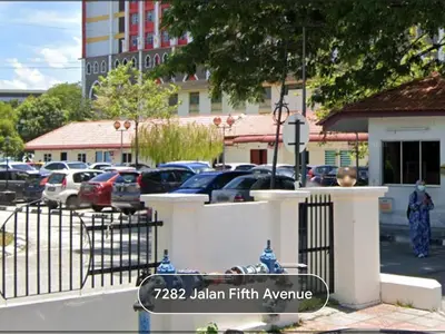 a fire hydrant in a parking lot next to a fence at Kamar Musafir MMS in Ipoh