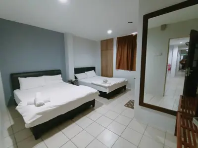 a bedroom with a large bed and a mirror at Reintree Lodge Hotel in Ipoh