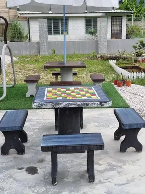 a picnic table with three benches and an umbrella at Tambun Hillview Cottage 1 in Tambun