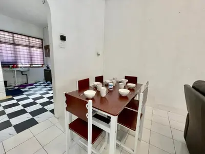 a dining table and chairs in a living room at Cozy 10 Entire House 4 Bedroom At Alma Bukit Mertajam in Bukit Mertajam