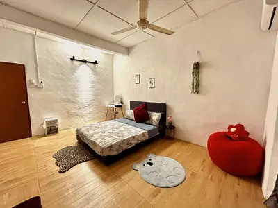 a bedroom with a bed and a large red ottoman at Cozy 10 Entire House 4 Bedroom At Alma Bukit Mertajam in Bukit Mertajam