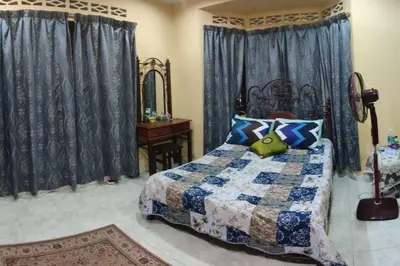 a bedroom with a bed and a mirror and curtains at Mai KKB Homestay in Kuala Kubu Bharu Taman Juta in Kuala Kubu Baharu