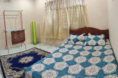 a bedroom with a bed with a blue and white quilt at Mai KKB Homestay in Kuala Kubu Bharu Taman Juta in Kuala Kubu Baharu