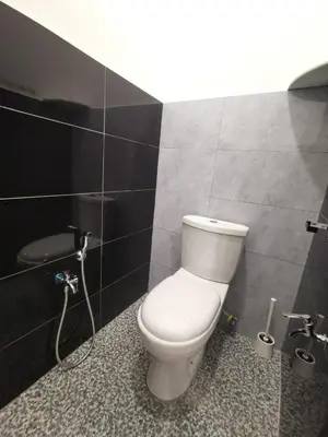 a bathroom with a white toilet in a black wall at Wellson Home Ipoh 58 10px \u5168\u65b0\u94fe\u63a5\u5f0f\u6c11\u5bbf\u6709\u4e24\u95f4 in Ipoh