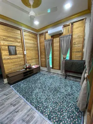 a room with a large rug and a chair and window at HOMESTAY DUSUN ANA BALUN in Slim River