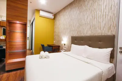 a bedroom with a large white bed with white towels on it at CitiVilla Hotel Penang in George Town