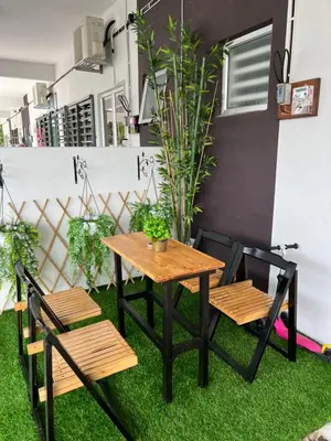 a table and two chairs and a table and chairs on grass at Mieda Rizqi Homestay in Kampong Melayu Changkat Larah