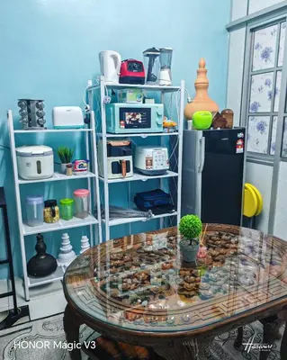 a room with a glass table and a refrigerator at Mieda Rizqi Homestay in Kampong Melayu Changkat Larah
