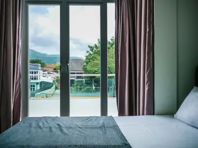 a bedroom with a bed and a large window at Joyful Guesthouse#IslandHosp in George Town