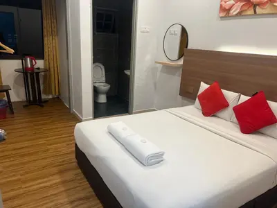 a white bed with red pillows in a room at ESM Hotel in Tanah Rata