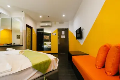 a hotel room with two beds and a tv at Golden Roof Hotel Ampang Ipoh in Ipoh